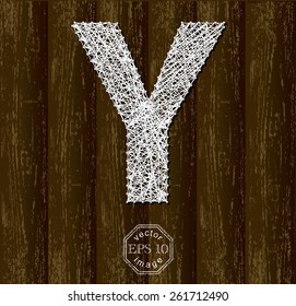 Letter Y, made with threads on pins on wooden background. Part of collection.