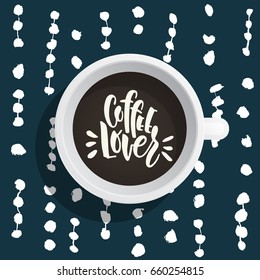 Lettering on the theme of coffee is hand-written. The phrase coffe lover written on the coffee Cup top view