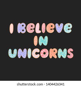 Lettering phrase: I believe in unicorns, on a black background. Letters stylized like donuts with colorful glaze and candy sprinkles.