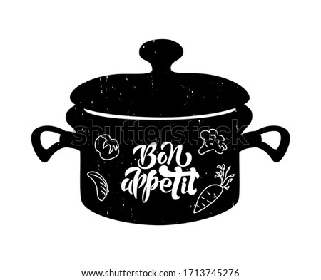 Lettering of phrase Bon Appetit on black pan with vegetables. Hand drawn typography poster. Inspirational vector typography. Vector calligraphy and pan illustration.