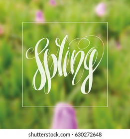 Lettering "Spring". Hand writing. White inscription against the background of spring greens