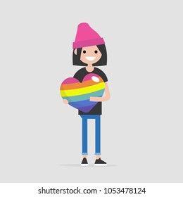 LGBTQ heart concept. Young female smiling character holding a big rainbow heart. Declaration of love. Flat editable vector illustration, clip art