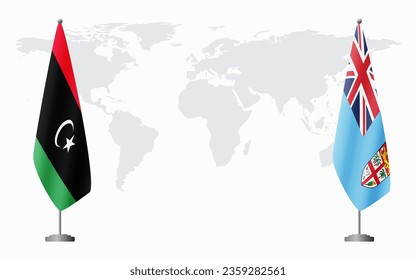 Libya and Fiji flags for official meeting against background of world map.