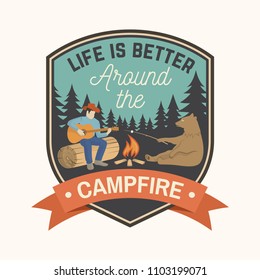 Life is better around the campfire. Vector illustration. Concept for shirt or logo, print, stamp or tee. Vintage typography design with campfire, bear, man with guitar and forest silhouette.