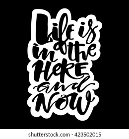 Life is in the here and now concept hand lettering motivation poster. Artistic modern brush calligraphy design for a logo, greeting cards, invitations, posters.