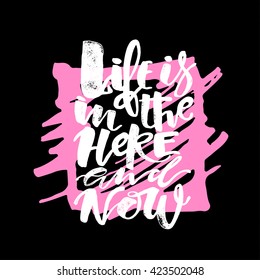 Life is in the here and now concept hand lettering motivation poster. Artistic modern brush calligraphy design for a logo, greeting cards, invitations, posters.