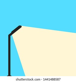 Light bulb emits white light on blue background.