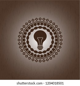 light bulb icon inside badge with wood background