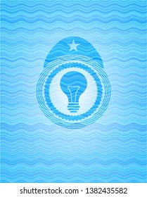 light bulb icon inside light blue water style badge.