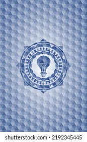 light bulb icon inside blue emblem with geometric pattern. 