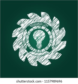 light bulb icon inside chalk emblem written on a blackboard
