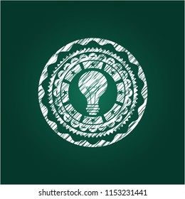 light bulb icon inside chalkboard emblem written on a blackboard