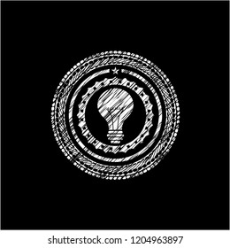 light bulb icon inside chalkboard emblem on black board