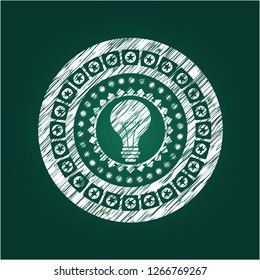 light bulb icon inside chalkboard emblem on black board