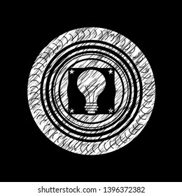 light bulb icon inside chalkboard emblem written on a blackboard