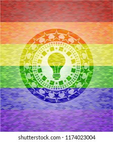 light bulb icon inside emblem on mosaic background with the colors of the LGBT flag