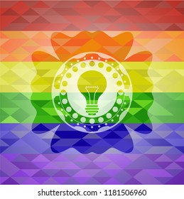 light bulb icon inside emblem on mosaic background with the colors of the LGBT flag