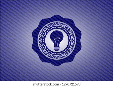 light bulb icon inside emblem with jean background