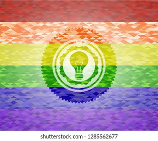 light bulb icon inside emblem on mosaic background with the colors of the LGBT flag