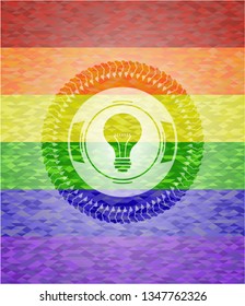 light bulb icon inside emblem on mosaic background with the colors of the LGBT flag