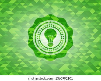 light bulb icon inside green emblem with triangle mosaic background
