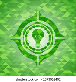 light bulb icon inside green emblem with mosaic ecological style background