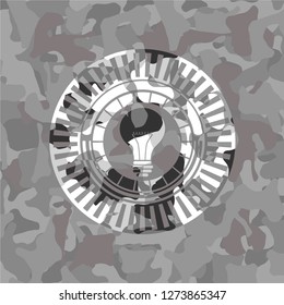 light bulb icon inside grey camouflage emblem