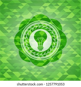 light bulb icon inside realistic green mosaic emblem