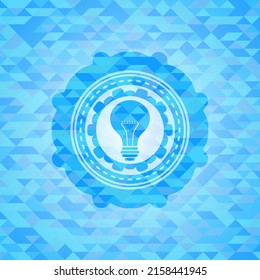 light bulb icon inside realistic sky blue emblem. Mosaic background. 