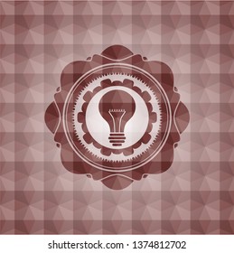 light bulb icon inside red seamless emblem or badge with abstract geometric pattern background.