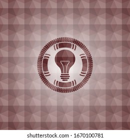 light bulb icon inside red seamless emblem or badge with abstract geometric polygonal pattern background.