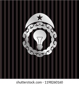 light bulb icon inside silvery emblem or badge