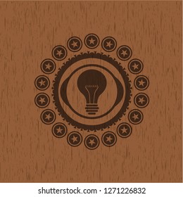 light bulb icon inside wooden emblem
