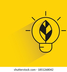light bulb and leaf with shadow yellow background