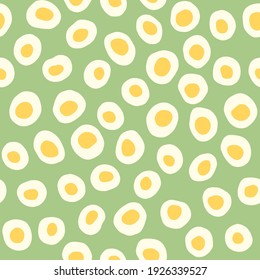 Light naive stilized simple jagged circles with yellow centres on a pastel green background. Vector seamless pattern for textile printing for children clothing or home textiles.