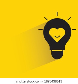 lightbulb and heart with shadow on yellow background