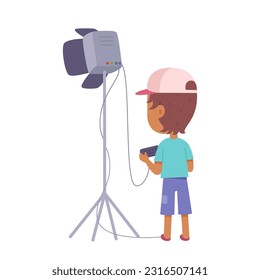 Lighting operator working with spotlight on tripod vector illustration. Cartoon isolated kid worker of film makers crew making light for movie, TV series or interview in studio, work process