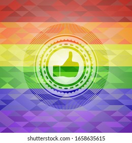 como un icono dentro del emblema sobre fondo de mosaico con los colores de la bandera LGBT