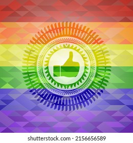 like icon inside emblem on mosaic background with the colors of the LGBT flag. 