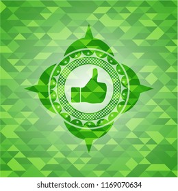 like icon inside green emblem. Mosaic background