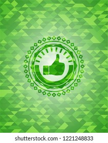 like icon inside green emblem. Mosaic background