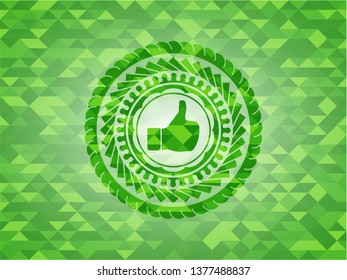 like icon inside green emblem. Mosaic background