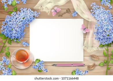 Lilac on wooden background. Spring top view composition with blank sheets of paper, blossoming tree branches, glass teacup and butterfly