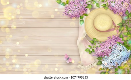 Lilac on wooden background. Spring top view composition with a straw hat, blossoming tree branches and butterfly