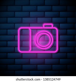 Lilac pink neon sign on brick wall Photo camera icon. Symbol for your web site design