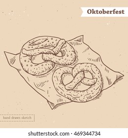 Linear sketch of the tasty pretzels on the napkin with text Oktoberfest. Hand drawn vintage vector illustration with german traditional food on the textured beige paper background.