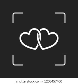 linked hearts icon. White object in camera autofocus on dark background