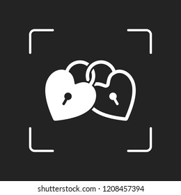 linked hearts, lock icon. White object in camera autofocus on dark background