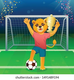 A lion in uniform standing on the ball and cheering with goblet on the soccer field