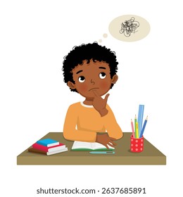 Little African boy thinking while studying doing his homework at the desk